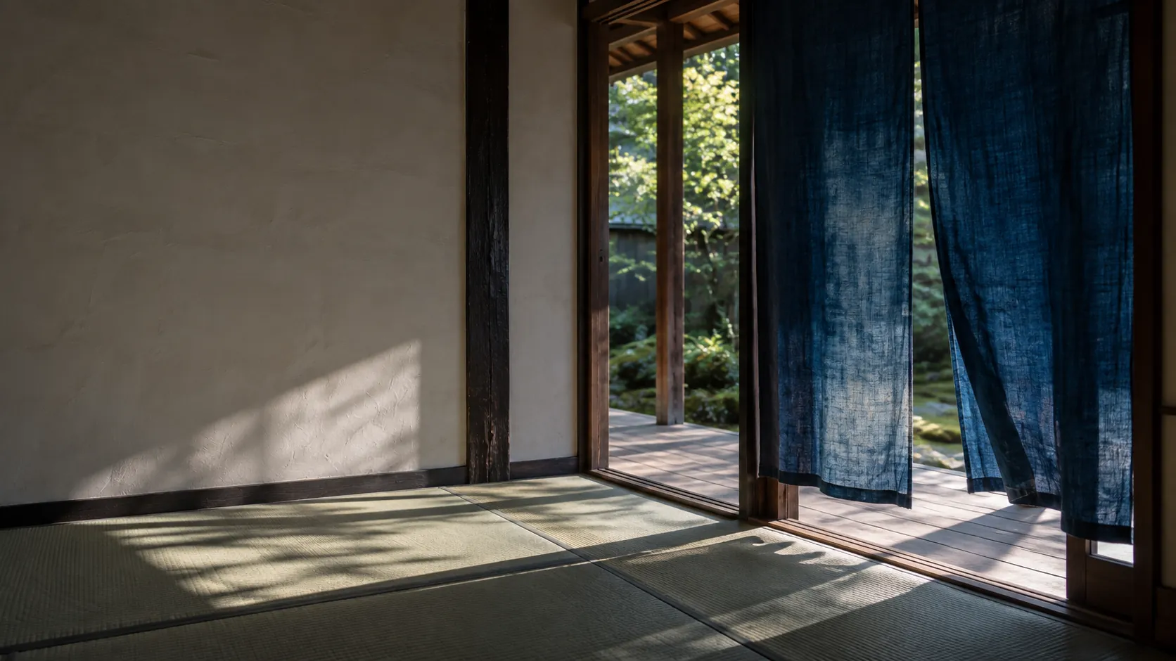 Morning sun across the tatami of a tea room, indigo noren curtains hanging in the doorway to the veranda